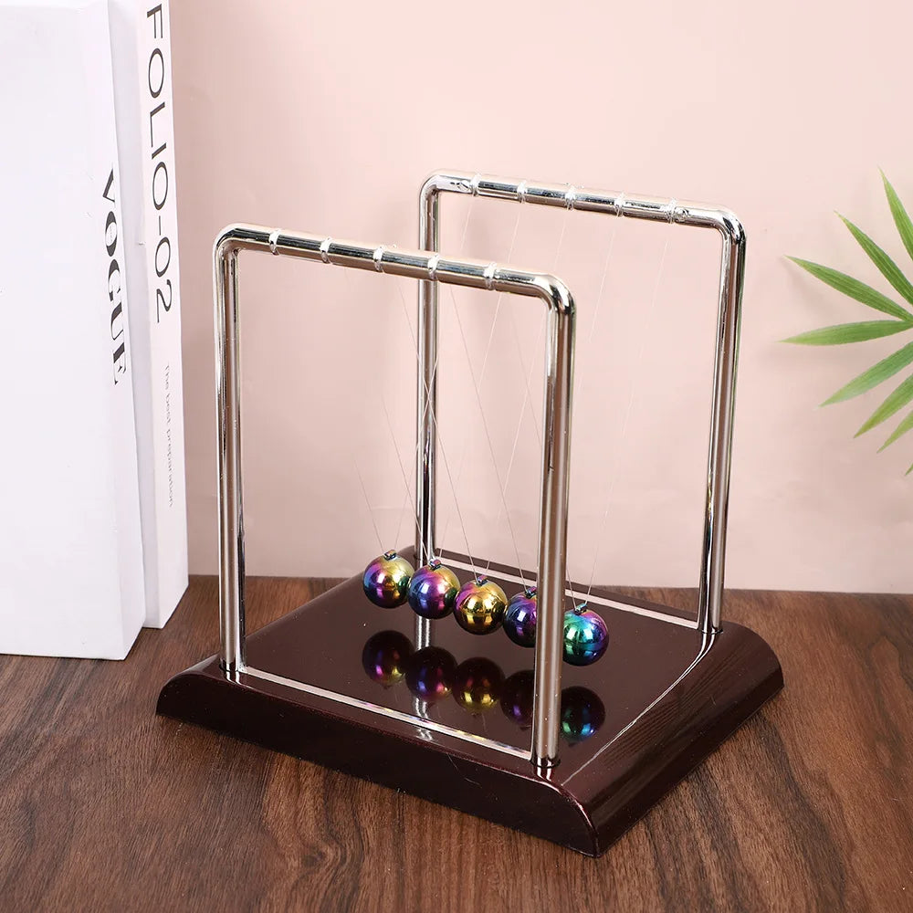 Péndulo de Newton con esferas metálicas multicolores sobre base de madera, decoración moderna de escritorio.
