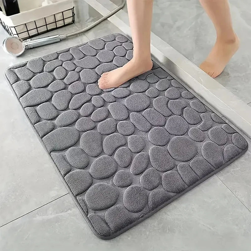 Alfombra gris antideslizante para baño con textura de piedras, ideal para pisos modernos