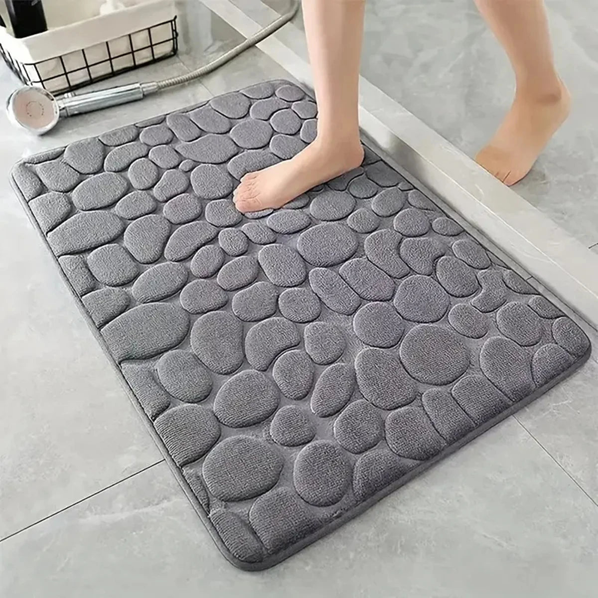 Alfombra gris antideslizante para baño con textura de piedras, ideal para pisos modernos