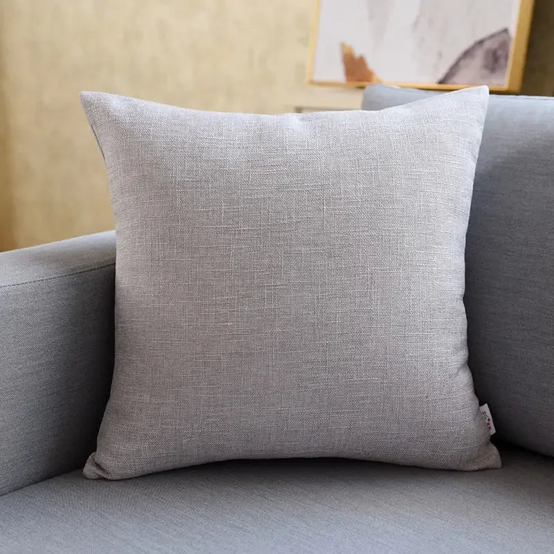 Cojín decorativo gris claro sobre sofá moderno, accesorio textil para sala de estar