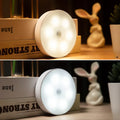 Luz LED redonda con sensor de movimiento, dos temperaturas de color, sobre mesa decorada.